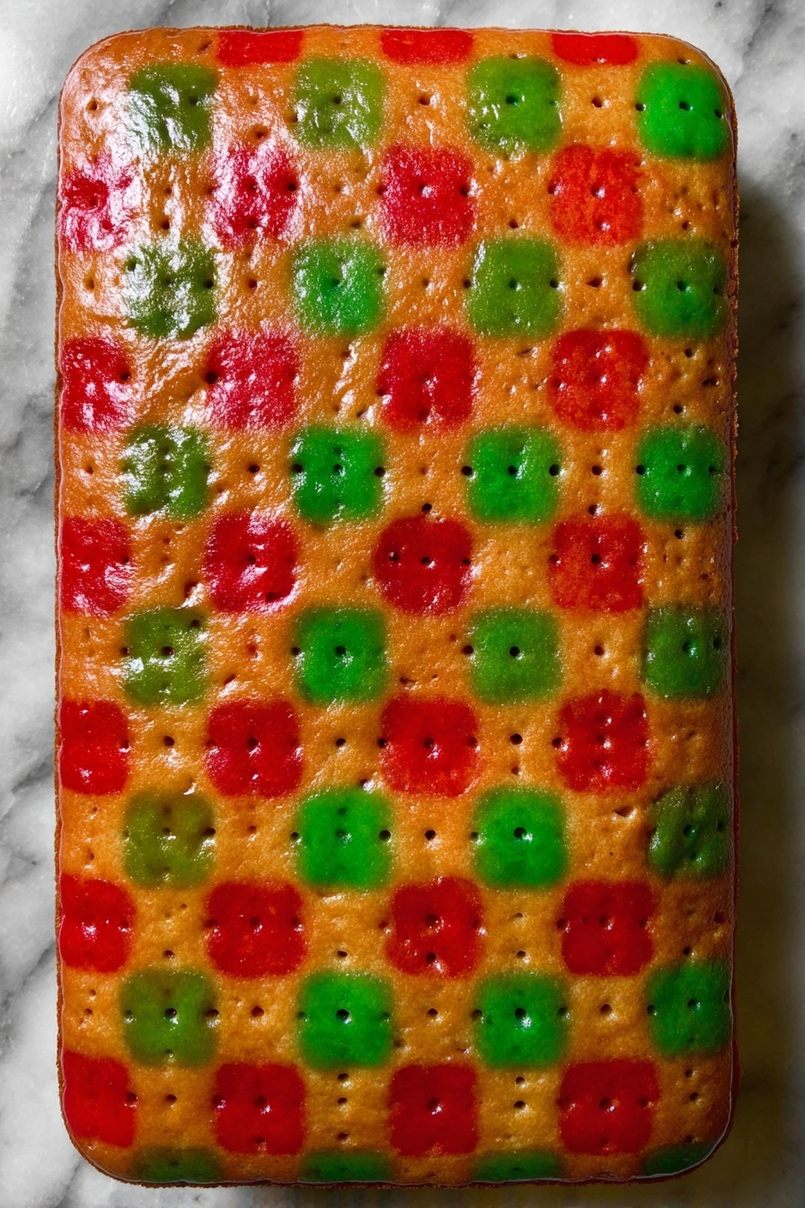 A baked rectangular cake with a smooth golden brown base layer, topped with a colorful checkerboard pattern of red and green glossy patches evenly spread across the surface. The cake's surface shows small holes aligned in rows, adding texture to the vibrant colors. The edges of the cake are rounded and slightly darker than the center, and the whole cake rests on a white marbled surface. photo taken with an iphone --ar 2:3 --v 7